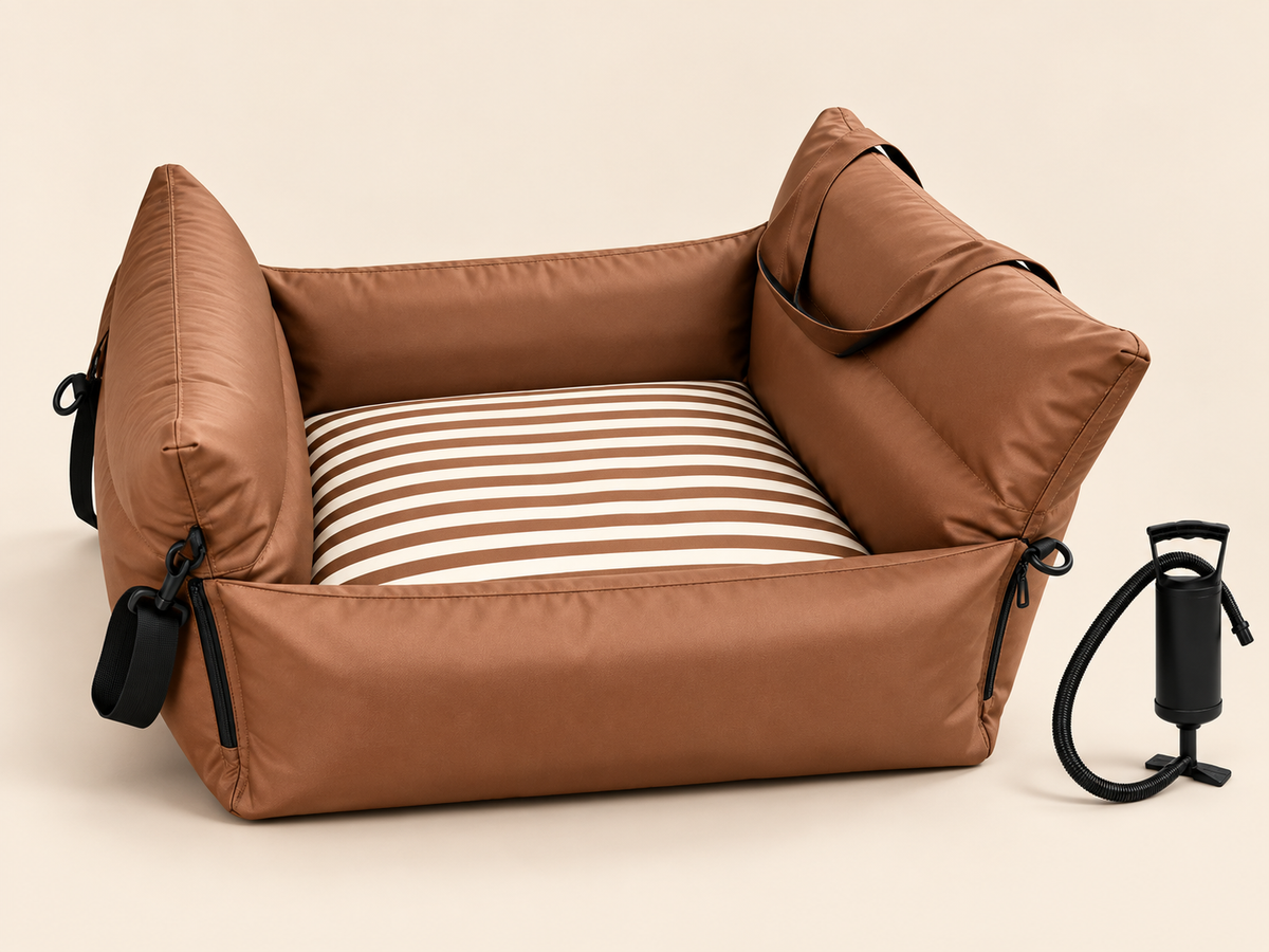 Coffee brown inflatable pet car seat with included hand pump on a warm neutral background